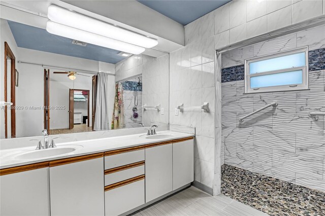 4706 SE Manatee Ter, Stuart, FL 34997 - full bath with tiled shower, double vanity, a ceiling fan, and tile patterned floors