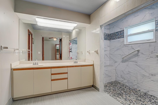 bathroom featuring tiled shower and vanity