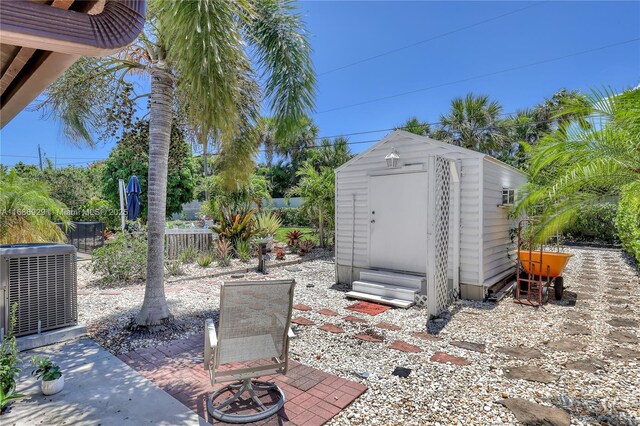 4706 SE Manatee Ter, Stuart, FL 34997 - view of patio featuring central AC unit, a storage shed, an outbuilding, and fence