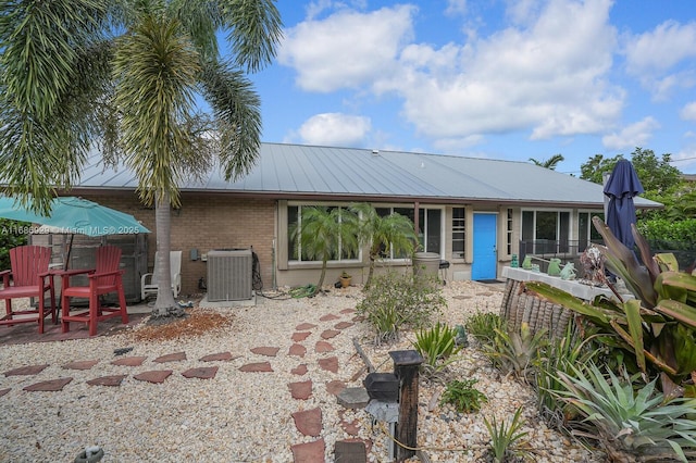 rear view of house with central AC unit and a patio