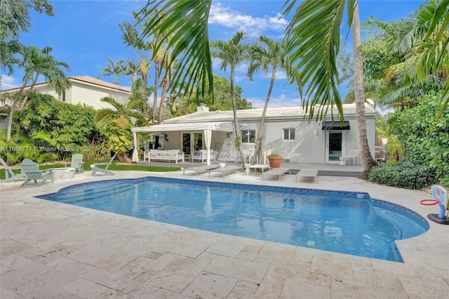 outdoor pool with french doors and a patio area