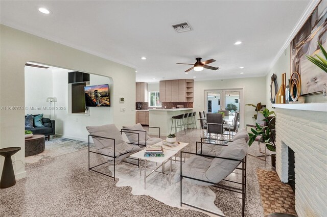 kitchen featuring light brown cabinetry, crown molding, stainless steel range with gas cooktop, kitchen peninsula, and backsplash