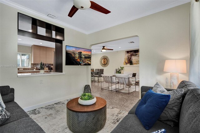 living room featuring crown molding and ceiling fan