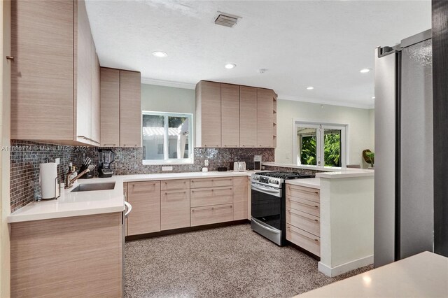 kitchen with light brown cabinetry, sink, decorative backsplash, and stainless steel gas range oven