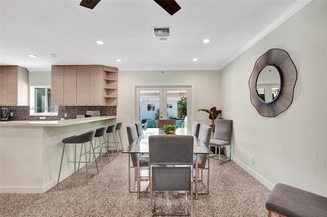 dining area with crown molding and ceiling fan