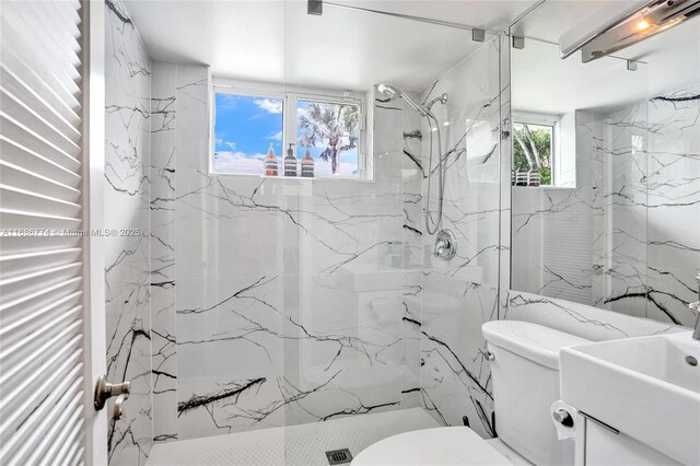 bathroom with vanity, toilet, and a tile shower