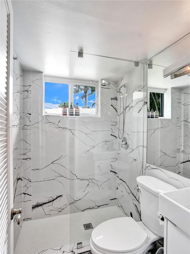 bathroom featuring tiled shower, vanity, and toilet