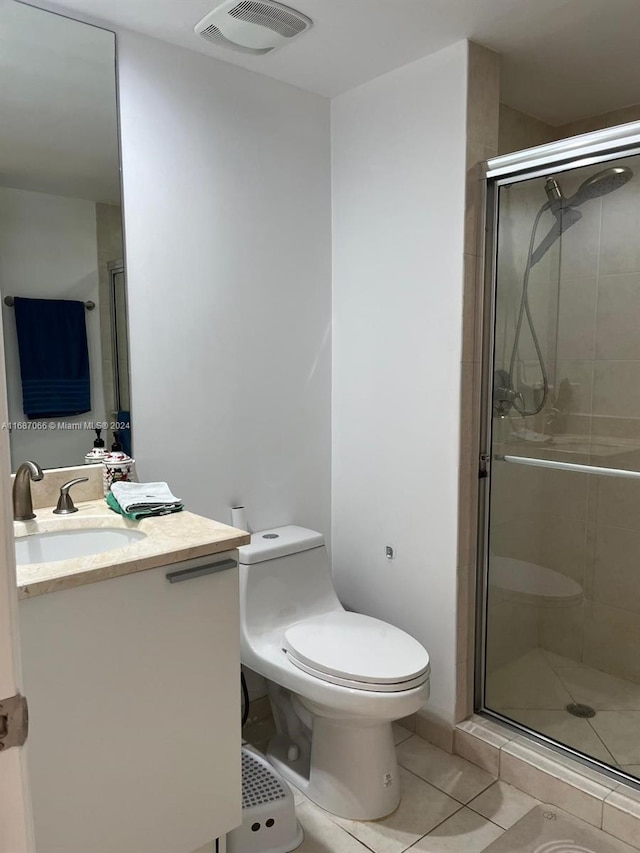 bathroom featuring vanity, toilet, tile patterned floors, and an enclosed shower