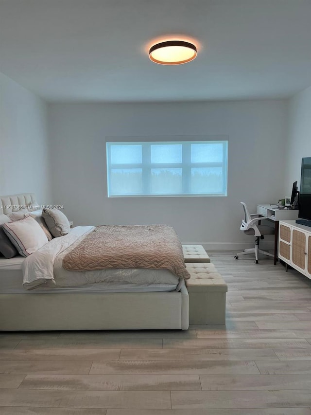 bedroom featuring light hardwood / wood-style floors and multiple windows