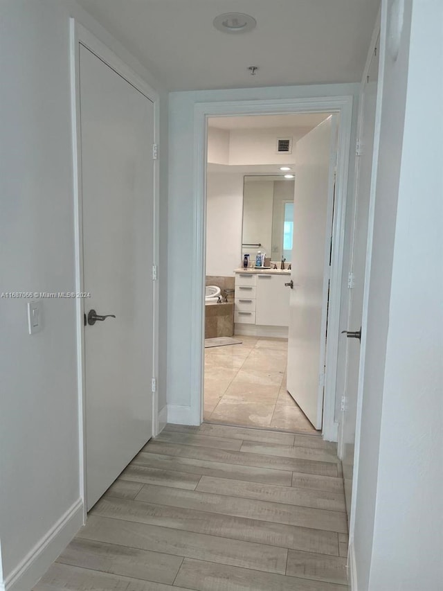 corridor with light wood-type flooring