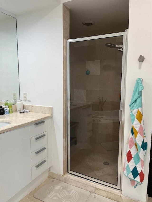 bathroom featuring vanity, walk in shower, and tile patterned flooring