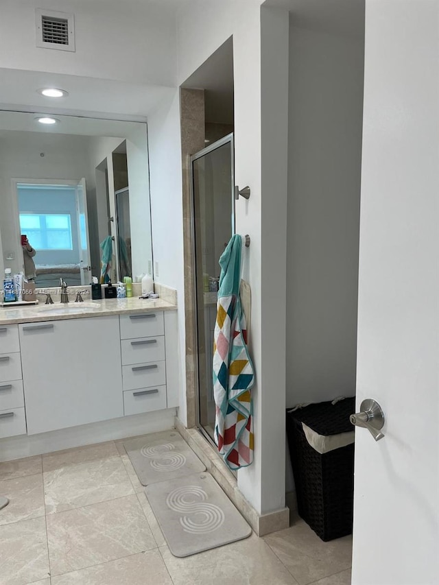 bathroom with vanity, tile patterned floors, and a shower with door