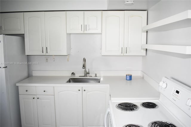 kitchen featuring white appliances, sink, and white cabinets