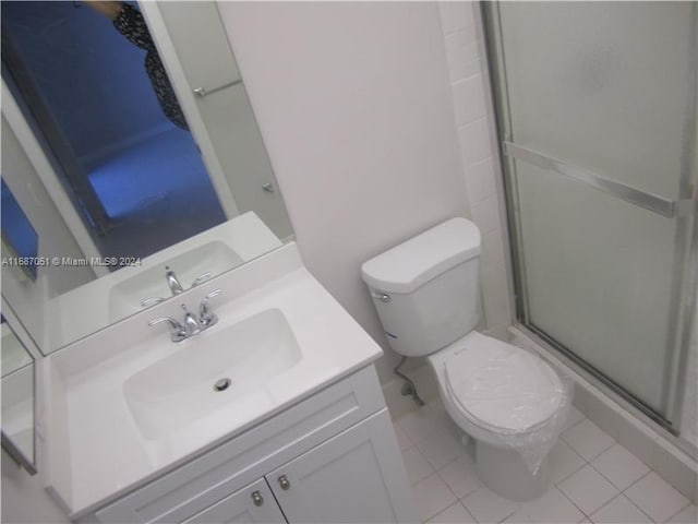 bathroom with vanity, toilet, tile patterned floors, and walk in shower