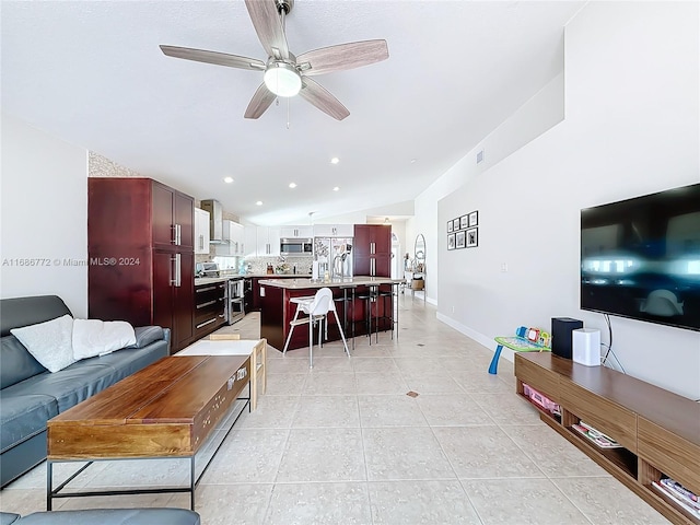 tiled living room with ceiling fan and vaulted ceiling