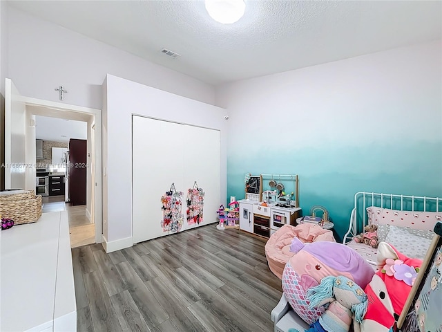 recreation room with hardwood / wood-style floors and a textured ceiling