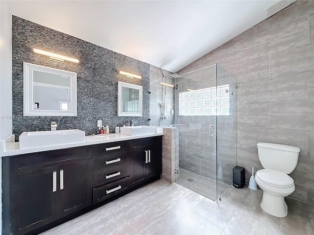 bathroom with lofted ceiling, toilet, a shower with shower door, tile walls, and vanity