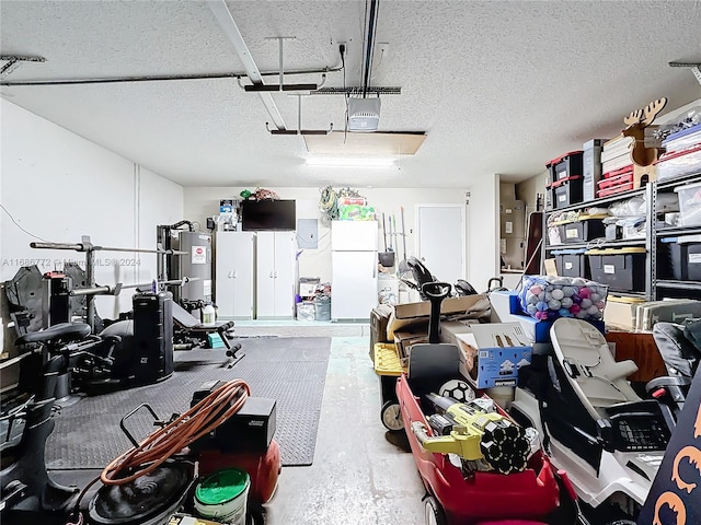 garage featuring a garage door opener, water heater, and white refrigerator