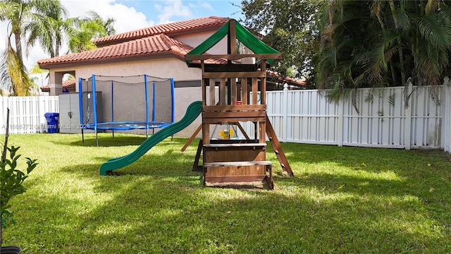 view of playground with a lawn and a trampoline