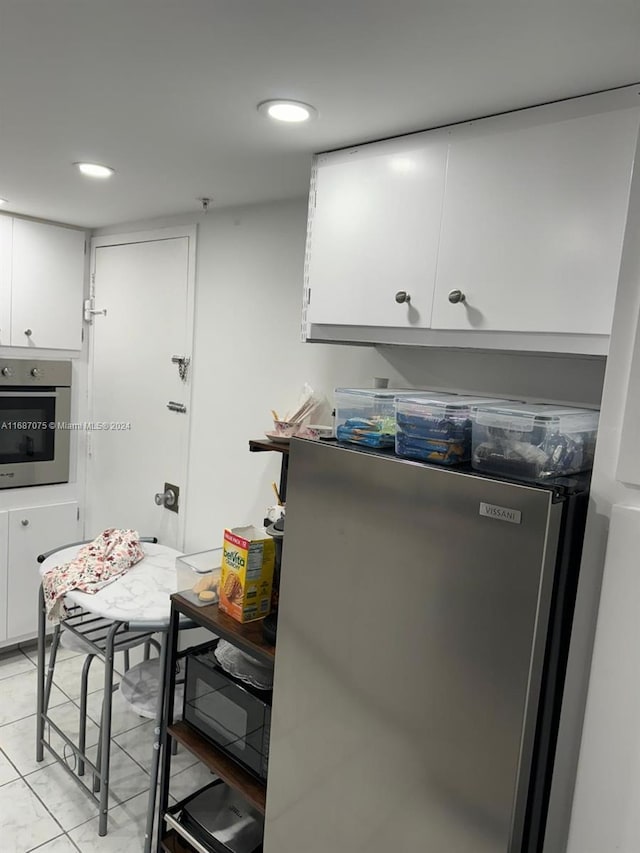 kitchen with stainless steel appliances, white cabinetry, recessed lighting, and light tile patterned floors