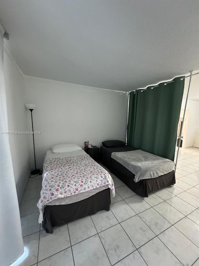 bedroom with light tile patterned floors and a textured ceiling