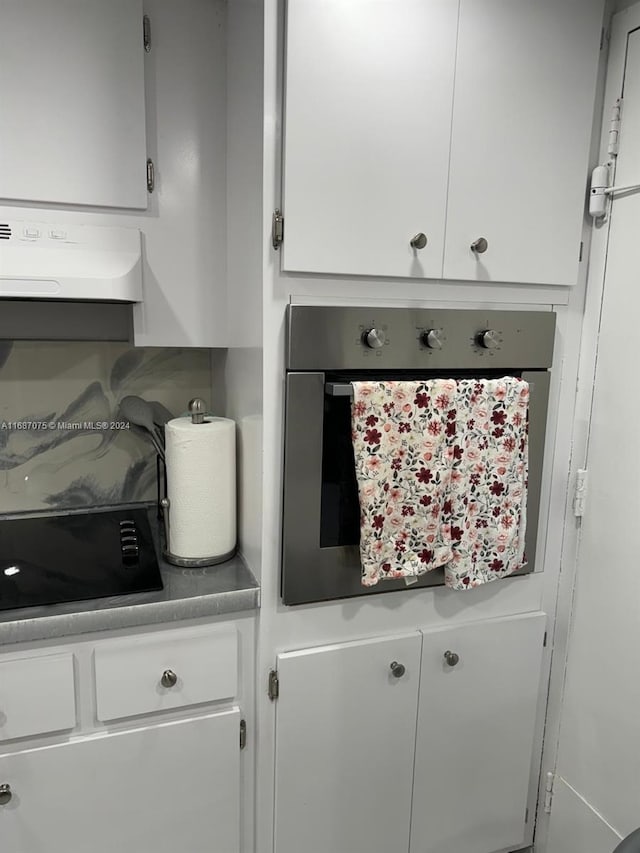 room details featuring black cooktop, extractor fan, and stainless steel oven