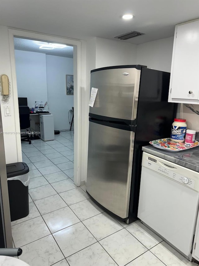 kitchen featuring white dishwasher, stainless steel fridge, and white cabinets