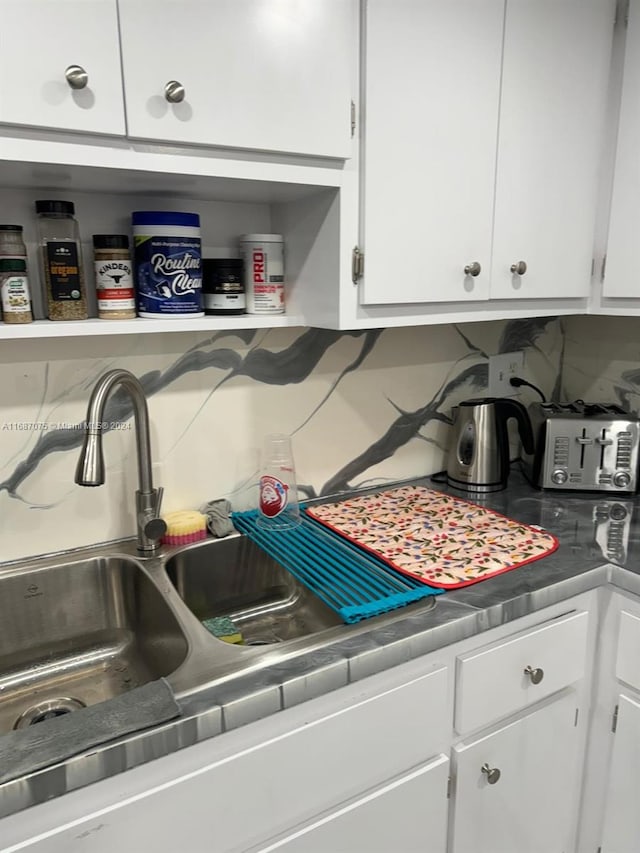 kitchen featuring tasteful backsplash and white cabinets