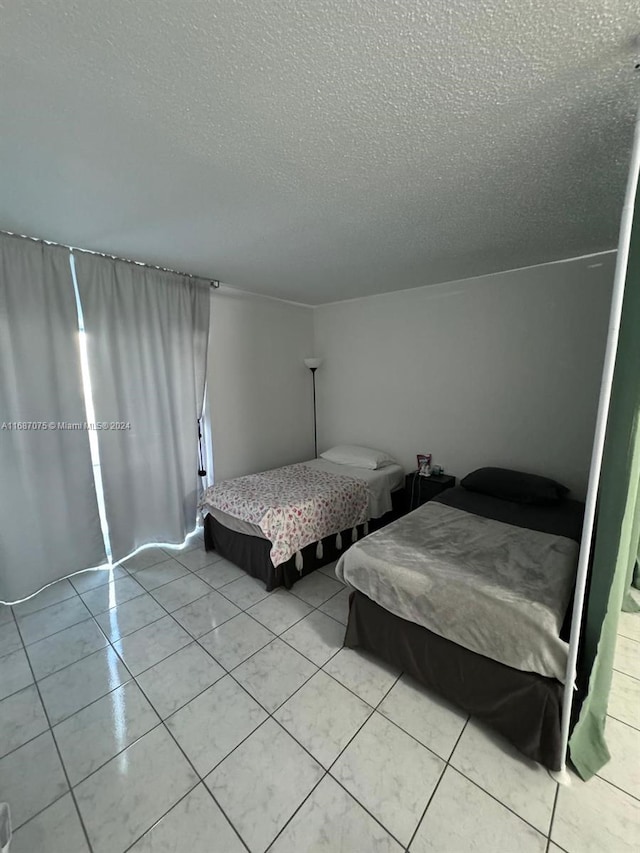 bedroom featuring a textured ceiling and light tile patterned floors