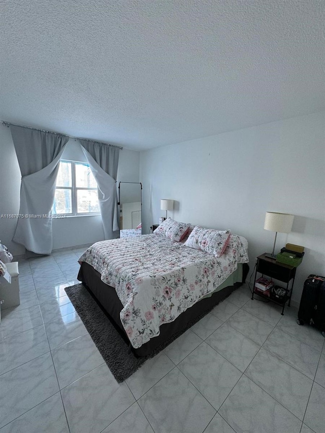 bedroom featuring a textured ceiling and light tile patterned flooring