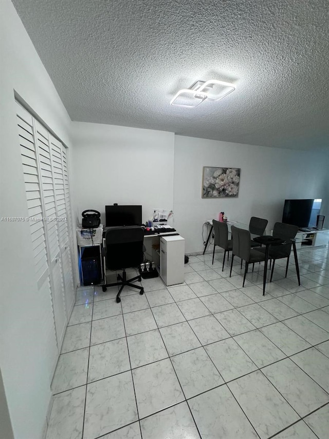 tiled home office with a textured ceiling