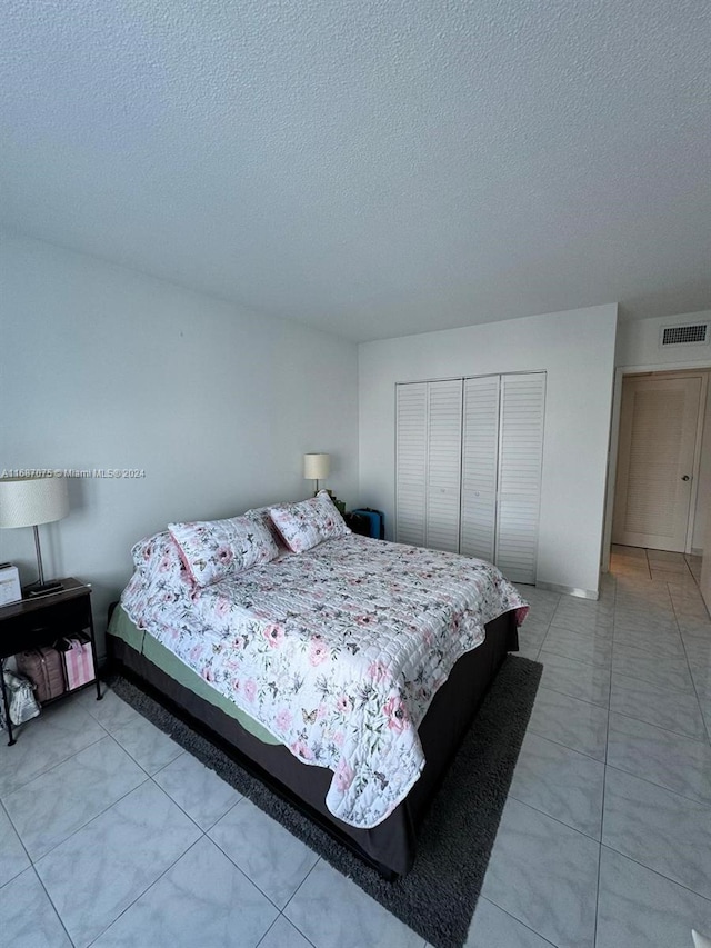 bedroom with a textured ceiling and a closet