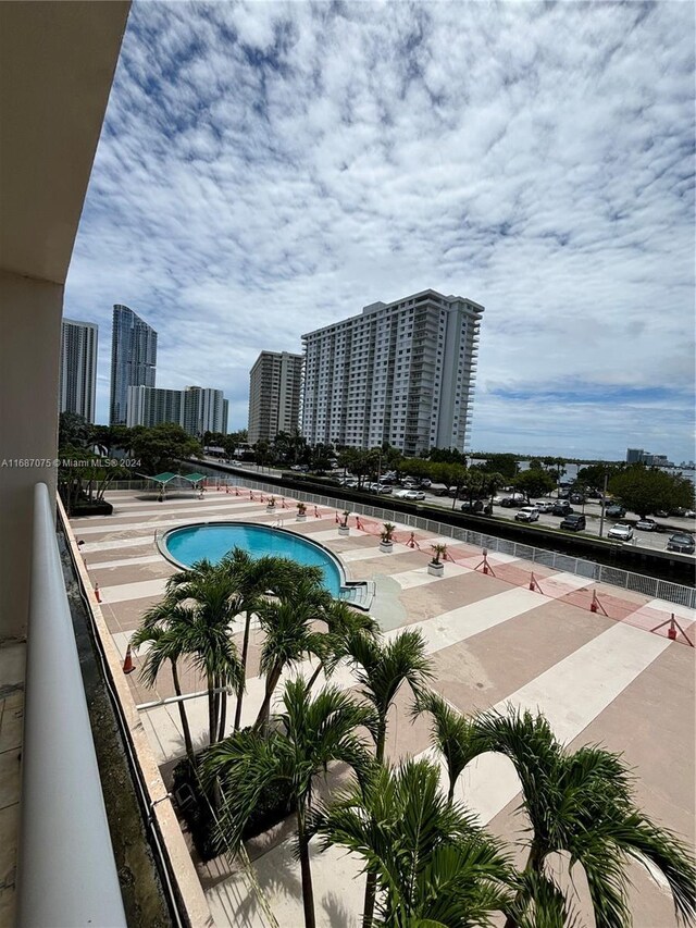 community pool with a view of city and a patio