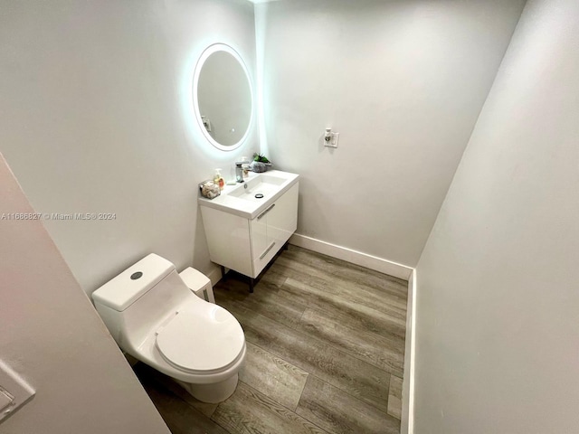 bathroom with vanity, toilet, and hardwood / wood-style flooring