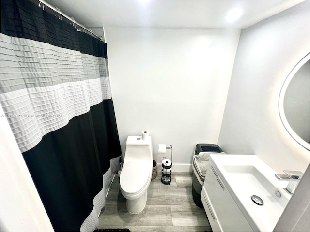 bathroom with vanity, hardwood / wood-style flooring, and toilet