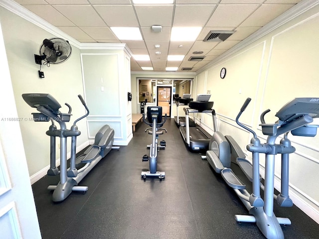 workout area with crown molding and a paneled ceiling