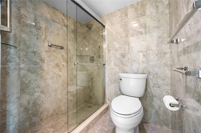 bathroom with toilet, tile walls, and an enclosed shower