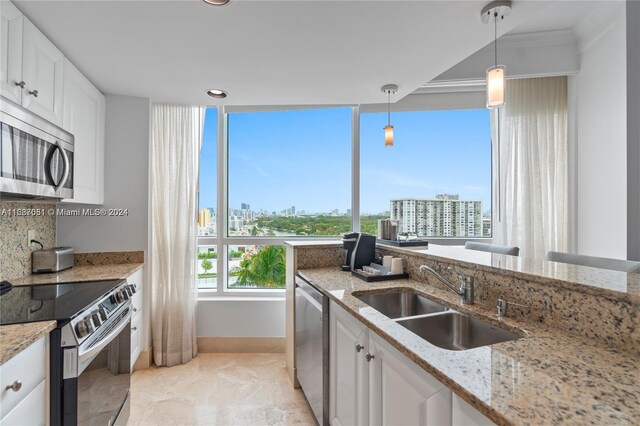 4401 Collins Ave Unit 1214, Miami Beach, FL 33140 - kitchen with stainless steel appliances, a city view, white cabinets, hanging light fixtures, and recessed lighting
