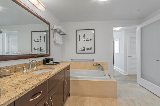 bathroom featuring hardwood / wood-style floors, vanity, and a tub