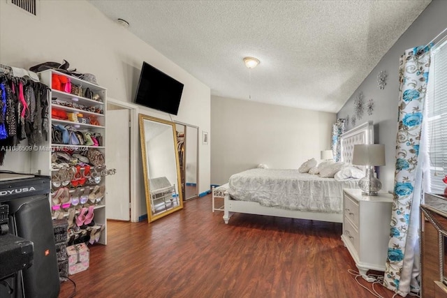 bedroom with a textured ceiling, lofted ceiling, and dark hardwood / wood-style floors