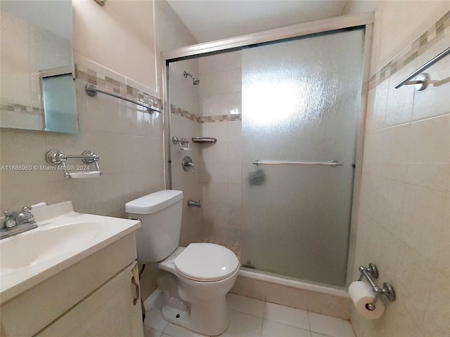 bathroom with walk in shower, vanity, and tile patterned floors