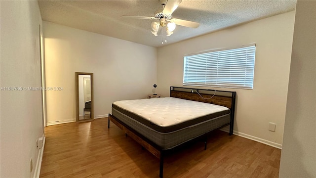 bedroom featuring hardwood / wood-style flooring, ceiling fan, and a textured ceiling