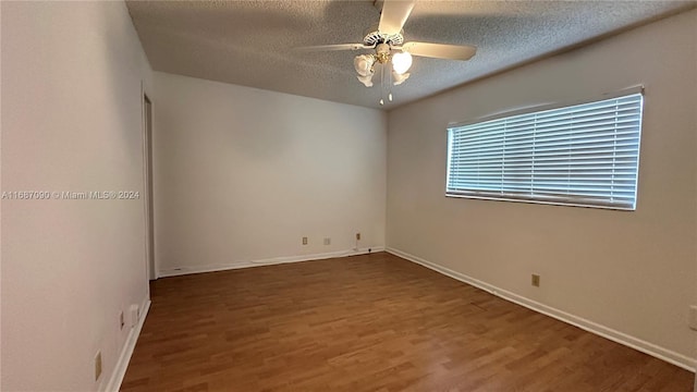 empty room with a textured ceiling, ceiling fan, and dark wood-type flooring