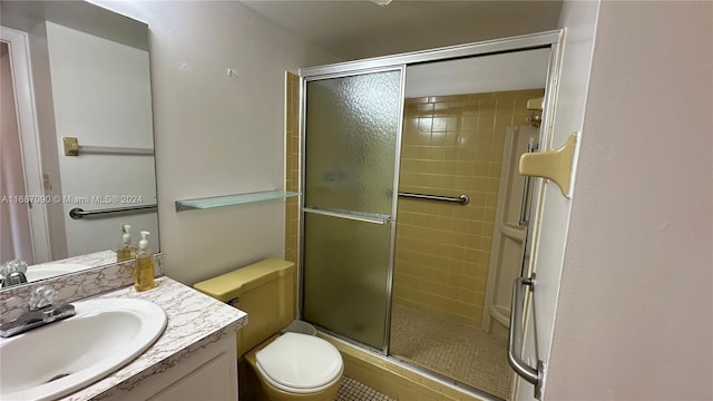 bathroom with an enclosed shower, vanity, and toilet