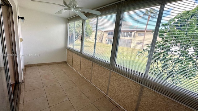 unfurnished sunroom featuring ceiling fan