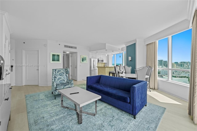 living room featuring light hardwood / wood-style flooring and ornamental molding