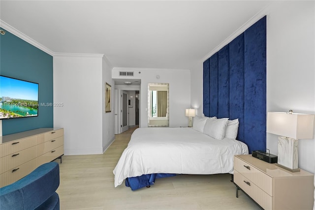 bedroom with ornamental molding and light hardwood / wood-style floors