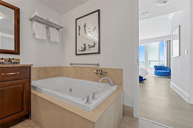 bathroom with vanity and tiled bath