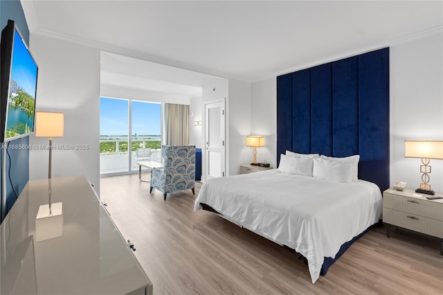 bedroom featuring light hardwood / wood-style flooring, ornamental molding, and floor to ceiling windows