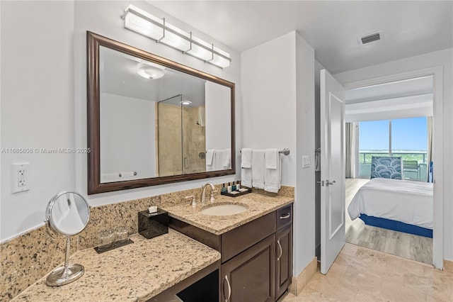 bathroom featuring a shower with door and vanity